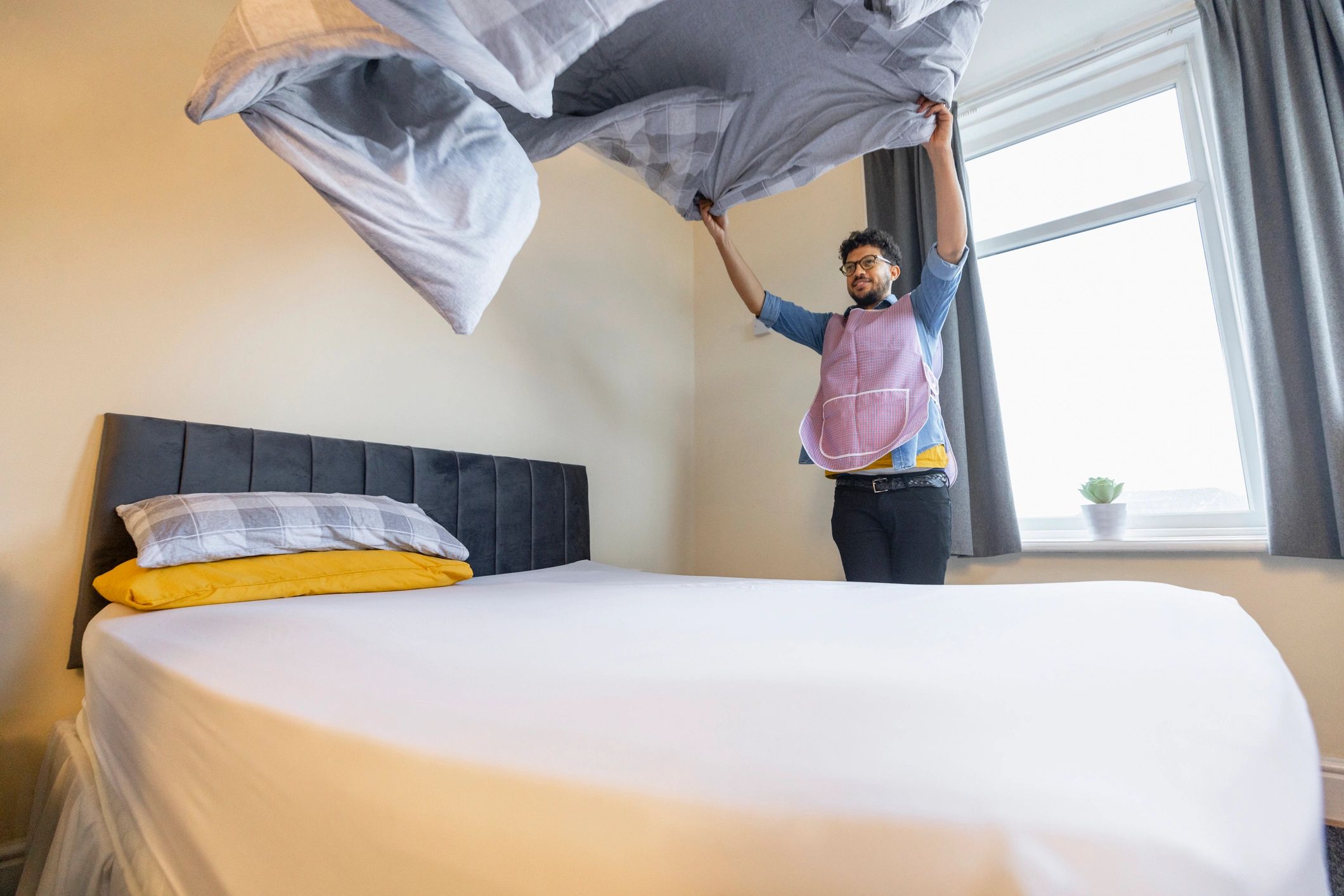 Working at the Hotel - White Trillium Cleaners Cleaner preparing a short-term rental bedroom